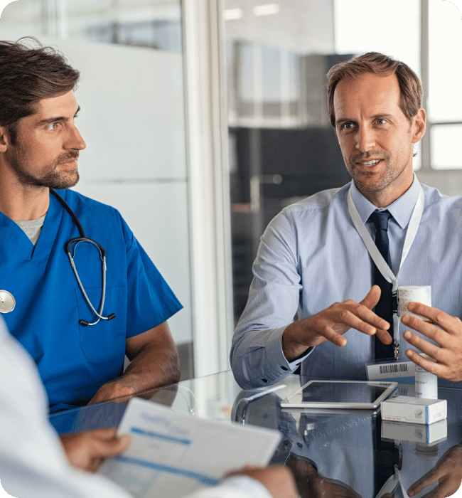 A doctor and healthcare employee sat discussing key healthcare challenges.